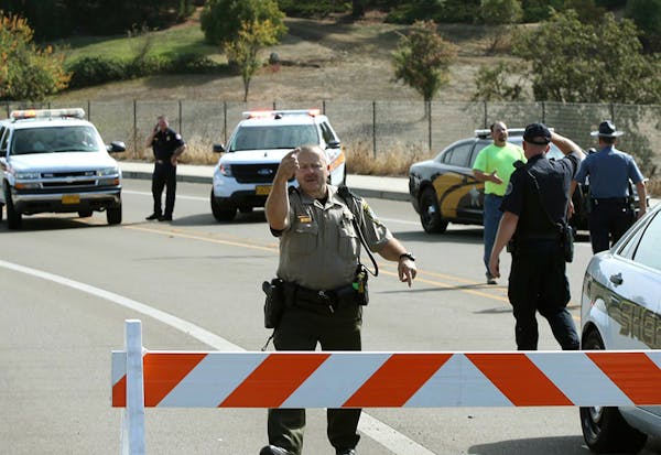 Officers direct traffic on a road leading to the Umpqua Community College campus in Roseburg, Ore., after a deadly shooting Thursday, Oct. 1, 2015.