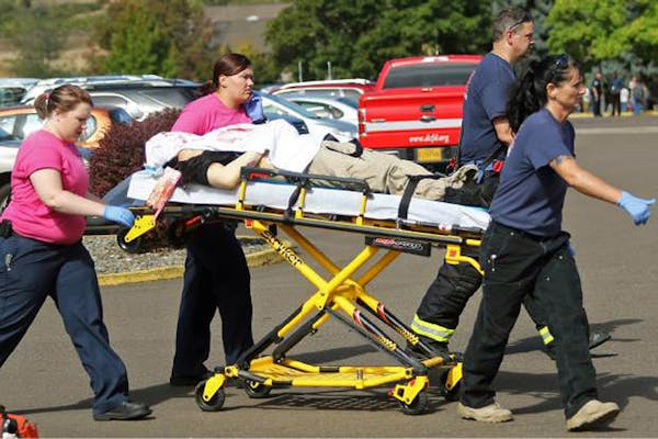 Authorities carry a shooting victim away from the scene after a gunman opened fire at Umpqua Community College in Roseburg, Ore., Thursday, Oct. 1, 20