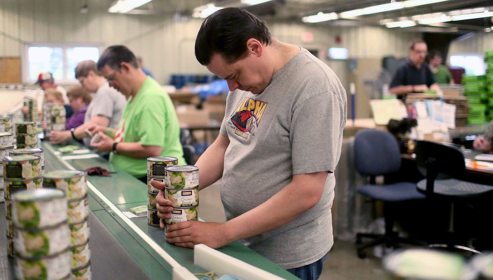 Dustin Leibfried, 42, who has toiled for years at a sheltered workshop in Fairmont, Minn.,  stacked cans of chicken on a fast-moving conveyor belt known as the “T-Rex.” “There are some days when you feel like you’re just racing, racing to catch up.”