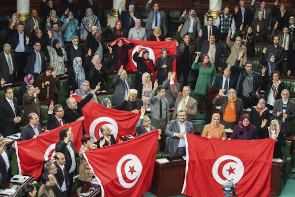 FILE - In this Sunday, Jan. 26, 2014 file photo, members of the Tunisian National Constituent Assembly celebrate the adoption of the new constitution 