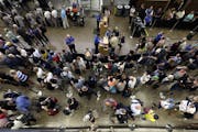 In this Tuesday, Aug. 11, 2015 photo, travelers wait in long security lines at Seattle-Tacoma International Airport, in Seattle.