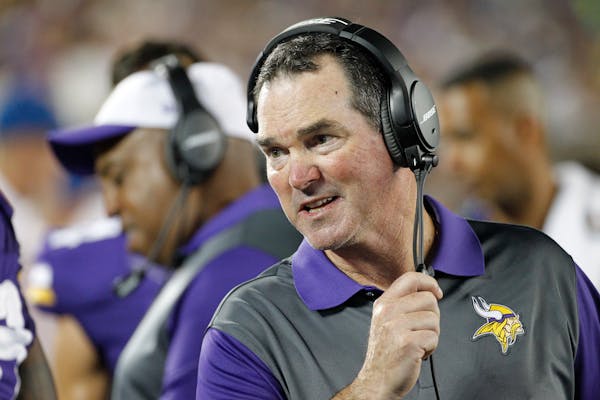 Minnesota Vikings head coach Mike Zimmer talks with his players in the second half of a preseason NFL football game against the Tampa Bay Buccaneers a