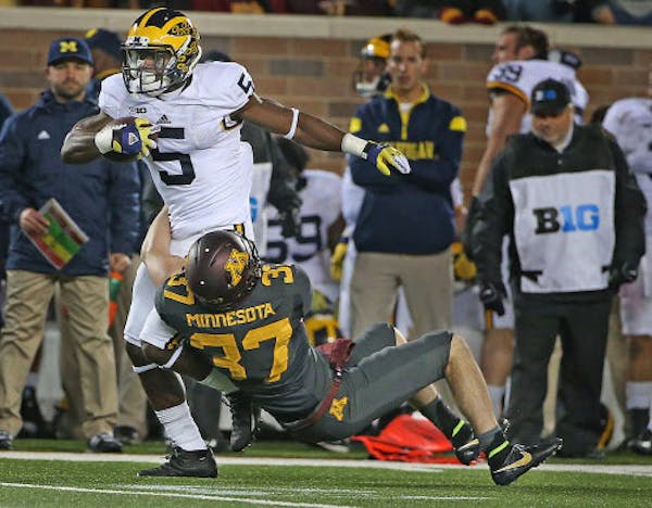 Michigan's Jabrill Peppers carried the ball as Gophers punter Peter Mortell tried to tackle him in the second quarter Saturday.