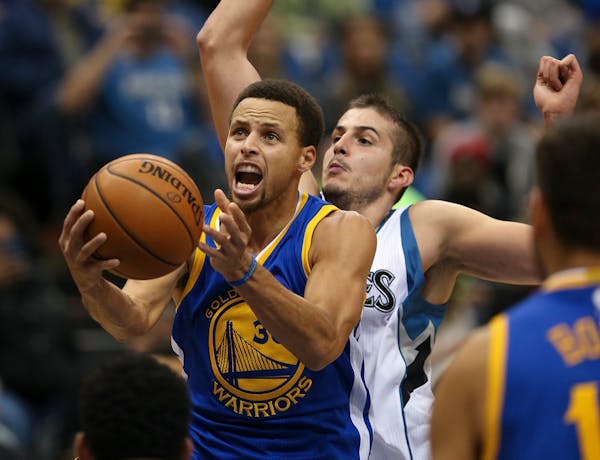 Golden State Warriors guard Stephen Curry (30) put up a second quarter shot past the defense of Timberwolves forward Nemanja Bjelica.