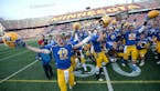 Minneota players, including quarterback Alex Pohlen (12), celebrated with their trophy after defeating Minneapolis North in the 1A championship game S