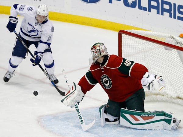 Minnesota Wild goalie Devan Dubnyk (40) deflects a shot in front of Tampa Bay Lightning left wing Ondrej Palat (18), of the Czech Republic, during the