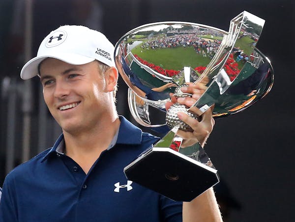 Jordan Spieth is presented the FedEx Cup after winning the Tour Championship golf tournament at East Lake Golf Club on Sunday, Sept. 27, 2015, in Atla