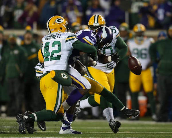 Vikings running back Adrian Peterson fumbled as he was tackled by Packers strong safety Morgan Burnett (42) after gaining 10 yards in the fourth quart