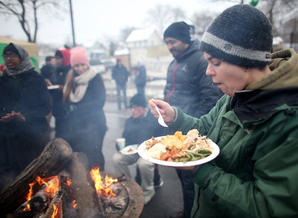 Ray Lockman ate her Thanksgiving dinner by the fire during BlackGiving event in front of the Minneapolis Fourth Precinct station.