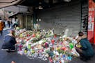 Flowers and candles are placed in front of the restaurant on Rue de Charonne, Paris, Sunday, Nov. 15, 2015, where attacks took place on Friday. The Is