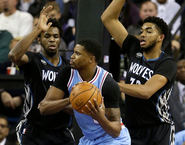 Sacramento forward Rudy Gay, center, is double-teamed by Minnesota's Andrew Wiggins, left, and Karl-Anthony Towns during the first quarter of an NBA b