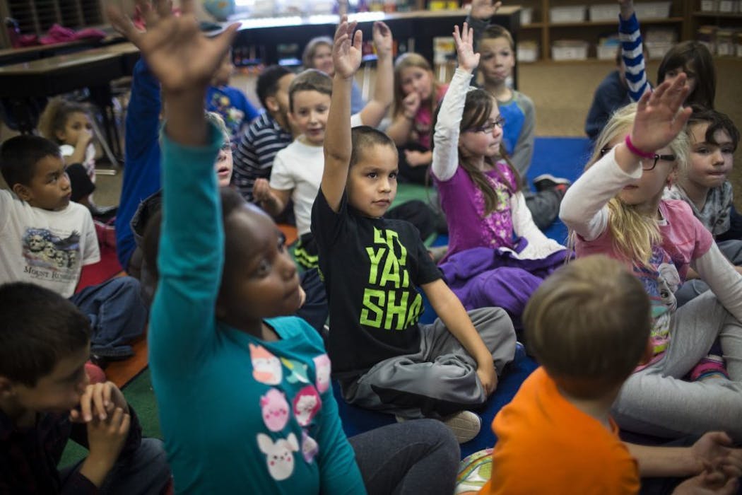 Second graders raise their hands during class at Sweeney Elementary School in Shakopee. Minority enrollment has more than doubled in Shakopee since 2000.