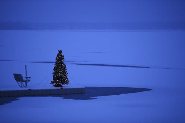 A Christmas tree on a dock in White Bear Lake in the snow Monday evening.