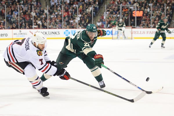 Minnesota Wild right wing Nino Niederreiter (22) and Chicago Blackhawks defenseman Brent Seabrook (7) tried to control the puck while racing down the 