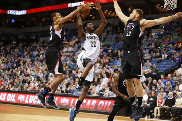 Minnesota Timberwolves guard Andrew Wiggins (22) shoots against Los Angeles Clippers forwards Wesley Johnson (33), left, and Blake Griffin (32) during