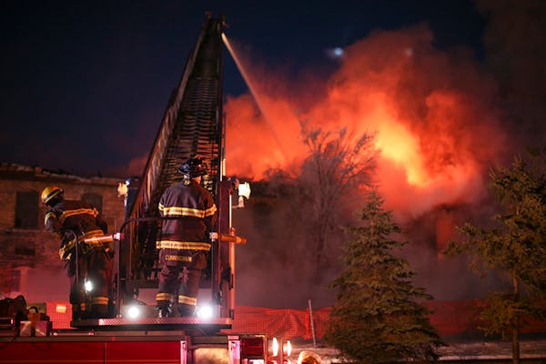 Minneapolis firefighters dumped water on the burning Harris Machinery Co. warehouse Sunday evening.