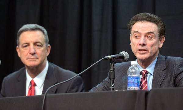 Louisville coach Rick Pitino, right, responds to a question as President of the Compliance Group Chuck Smrt listens during a press conference, Friday,