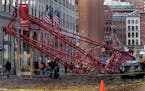 Officials survey the scene of a crane collapse in New York, Friday, Feb. 5, 2016. The crane landed across an intersection and stretched much of a bloc