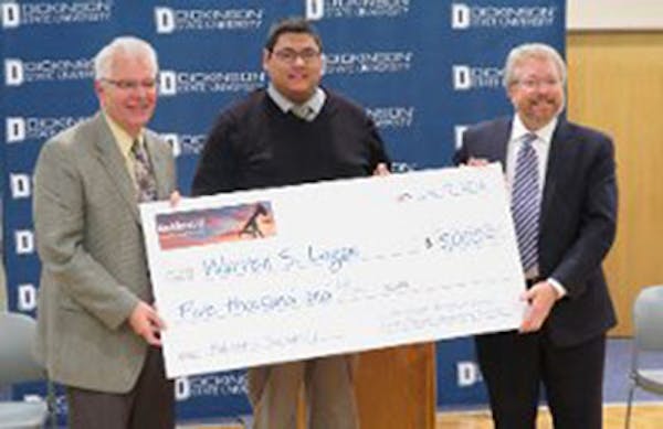 Warren Logan, center, a former oil field worker now enrolled at Dickinson State University, receives the inaugural Bakken U scholarship of $5,000. Wit