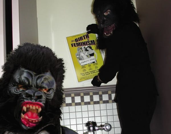 Guerrilla Girls Frida Kahlo and Kathe Kollwitz sticker a movie theater bathroom in Hollywood in 2003.