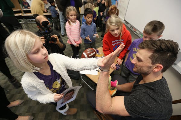 Kyleigh Duerr left gave a high five to Minnesota Vikings kicker Blair Walsh after giving him a stuffed animal. Walsh thanked first graders at Northpoi