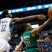 Minnesota Timberwolves' Andrew Wiggins, left, reaches in vain for the ball as Boston Celtics' Avery Bradley lays up a shot during the first quarter of