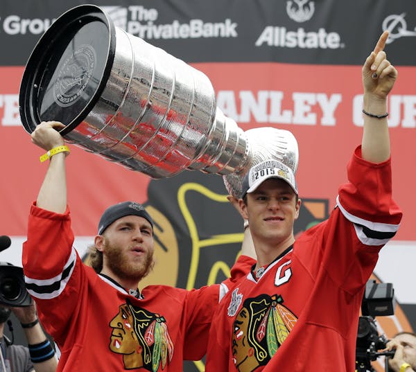 Hoisting the Stanley Cup never gets old for Chicago’s Patrick Kane, left, and Jonathan Toews, who did it again last June at a Soldier Field rally. T
