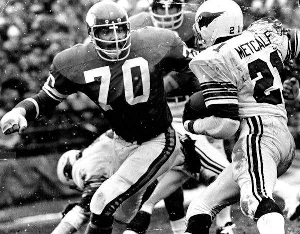 December 22, 1974 Jim Marshall (70) and Wally Hilgenberg (58) loomed in front of St. Louis's Terry Metcalf Saturday, holding him to short yardage. Dec