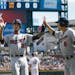 Minnesota Twins' Byron Buxton is congratulated by Aaron Hicks (32) and Kurt Suzuki (8) after scoring in the second inning of a baseball game against t