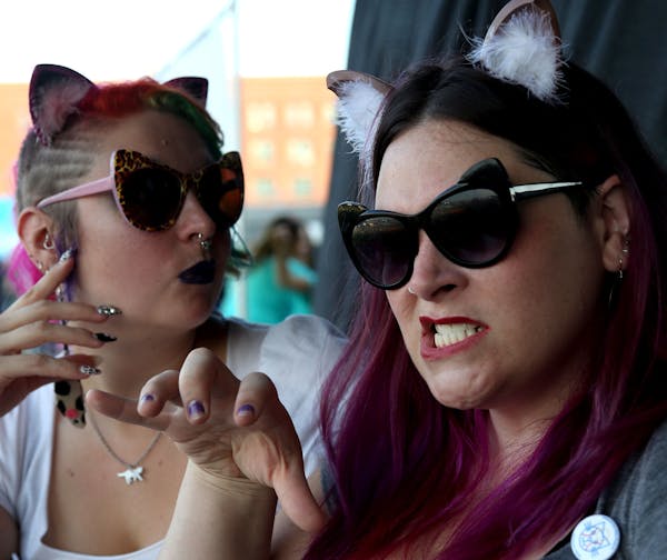 Lacie Zeiler, of Minneapolis, right and Renata Shaffer-Gottschalk make cat faces before the start of the Cat Video Festival hosted by the Walker Arts 