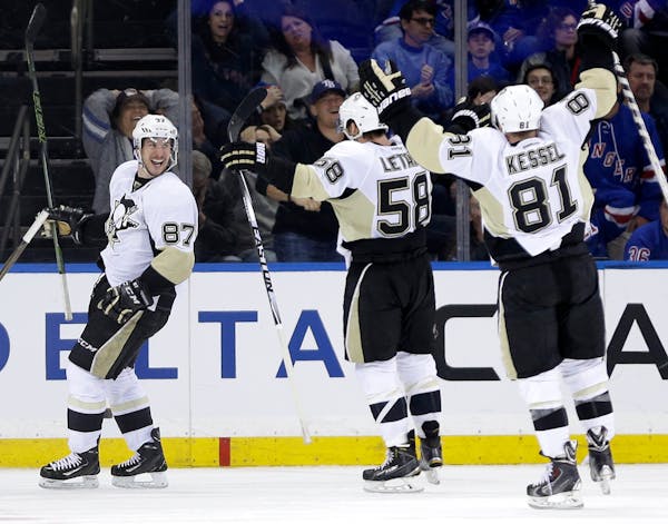 Pittsburgh Penguins' Sidney Crosby, left, celebrates his game winning goal with teammates Phil Kessel, right, and Kris Letang during the overtime peri