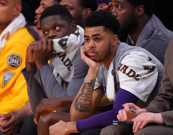 Los Angeles Lakers guard D'Angelo Russell, right, sits on the bench next to forward Julius Randle during the first half of the team's NBA basketball g