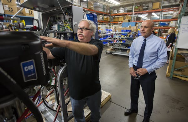 CEO Pat McHale, right, talked with Joe Christopherson on one of his many walks around the Graco plant. McHale has worked in factories since his high s