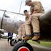 Parker Deters, left, of Duluth and Carter Moon of Inver Grove Heights chill atop a Vultee BT-13 WWII basic trainer while waiting to sell tickets for p