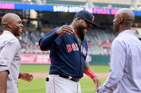 During a pre-game ceremony honoring Boston Red Sox and former Minnesota Twin David Ortiz, Ortiz is greeted by former Twin teammates LaTroy Hawkins, ri