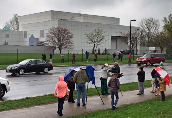 In this April 21, 2016 file photo, people stand outside entertainer Prince's Paisley Park compound in Chanhassen, Minn.
