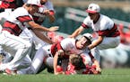 Minnehaha Academy pitcher Jesse Retzlaff (center) jumped on catcher Justin Evenson as teammates joined in the celebration after the Redhawks won the C