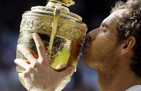 Andy Murray of Britain kisses the trophy after beating Milos Raonic of Canada in the men's singles final on day fourteen of the Wimbledon Tennis Champ