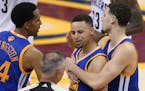 Golden State Warriors guard Stephen Curry is held back from referee Jason Phillips (23) by Shaun Livingston, left, and Klay Thompson, right, while rea
