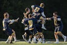Prior Lake players converge in celebration after defeating Lakeville North 12-5 in the state championship game on Saturday at Chanhassen High School.