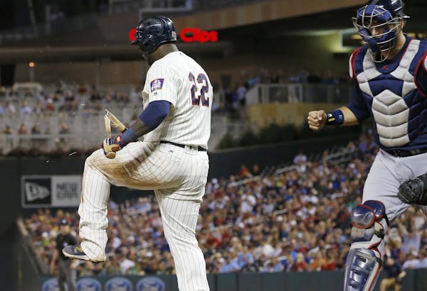 Atlanta Braves catcher A.J. Pierzynski, right, pumps his fist as Minnesota Twins' Miguel Sano, left, breaks his bat over his leg after striking out to