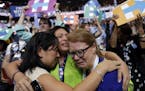 Carrie Pugh, left, Katrina Mendiola and Mayors Wegmann cry as Hillary Clinton officially becomes the first woman to be the presidential nominee of a m