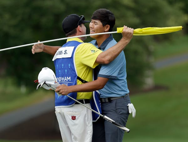 Si Woo Kim, right, hugs his caddie after winning the Wyndham Championship golf tournament in Greensboro, N.C., Sunday, Aug. 21, 2016. (AP Photo/Chuck 