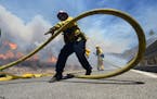 Firefighters battle the Bluecut Fire along Swarthout Canyon Road in the Cajon Pass, north of San Bernardino, Calif., Tuesday, Aug. 16, 2016. Officials