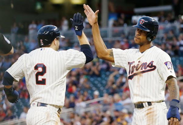Minnesota Twins' Brian Dozier, left, and Byron Buxton celebrate as they score on a two-run ground-rule double by Jorge Polanco off Chicago White Sox p