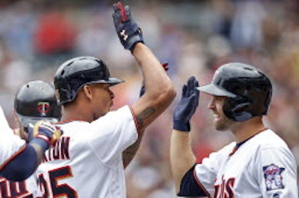 The Twins' Byron Buxton, left, celebrated with Brian Dozier after hitting a grand slam against the Chicago White Sox in the second inning Sunday.