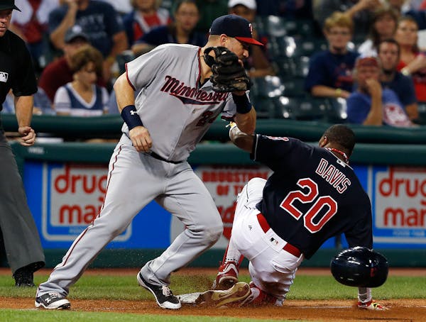 Cleveland Indians' Rajai Davis (20) steals third base as Minnesota Twins' Trevor Plouffe (24) tries to make the tag during the eighth inning of a base