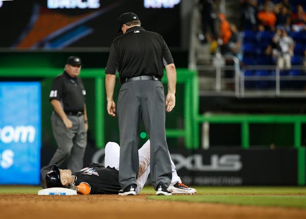Miami Marlins' Giancarlo Stanton lies at second base after he was put out during the ninth inning of a baseball game against the Chicago White Sox, Sa