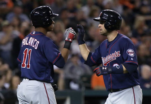 Minnesota Twins' Brian Dozier, right, is congratulated by Jorge Polanco after hitting a solo home run against the Detroit Tigers during the fourth inn