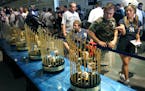 Yankees fans look at the seven World Series trophies won under George Steinbrenner's ownership of the New York Yankees before the baseball game betwee